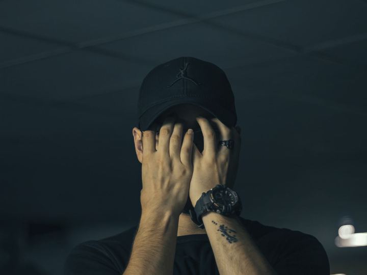 Hombre con gorra tapándose la cara
