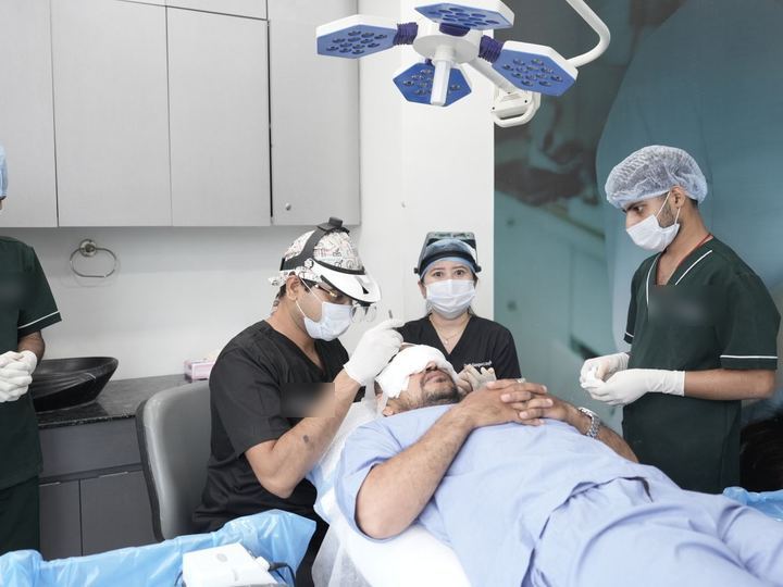 Equipo médico en una clínica atendiendo a un paciente con la cabeza vendada