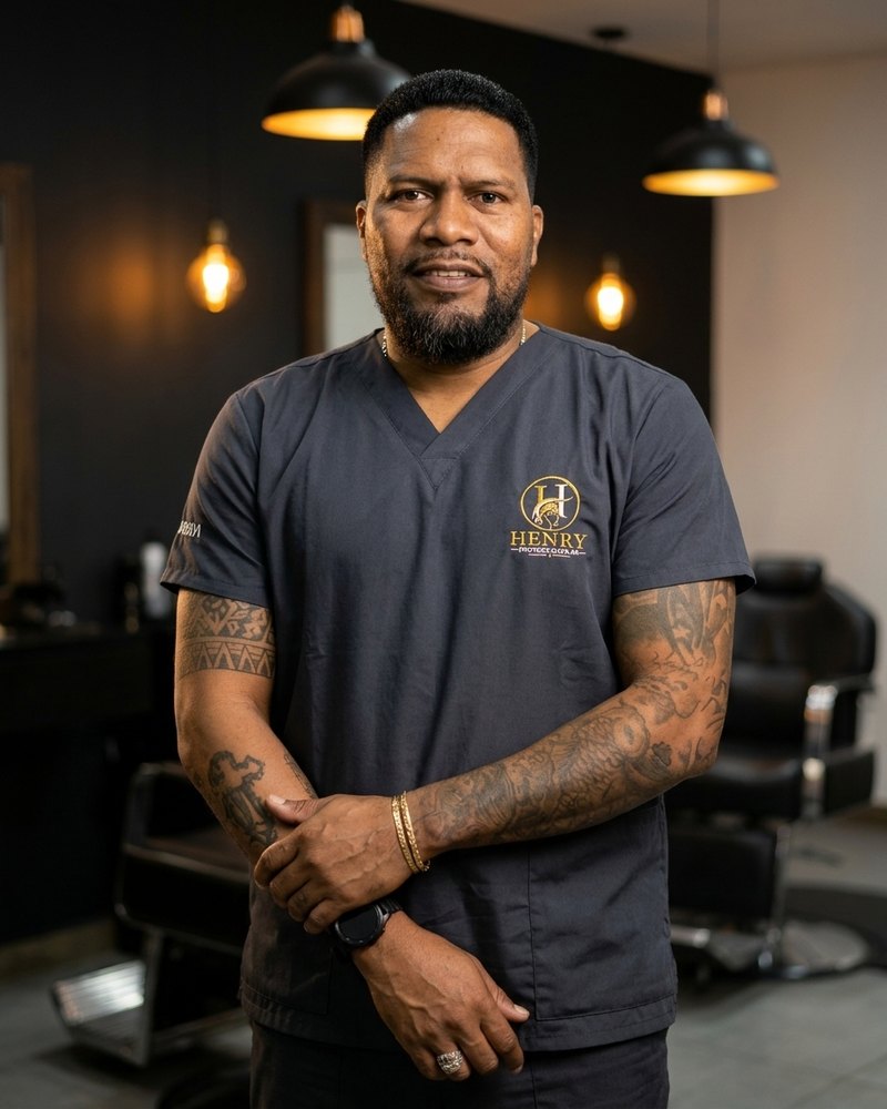 Henry, especialista en prótesis capilares, con su uniforme en la barbería