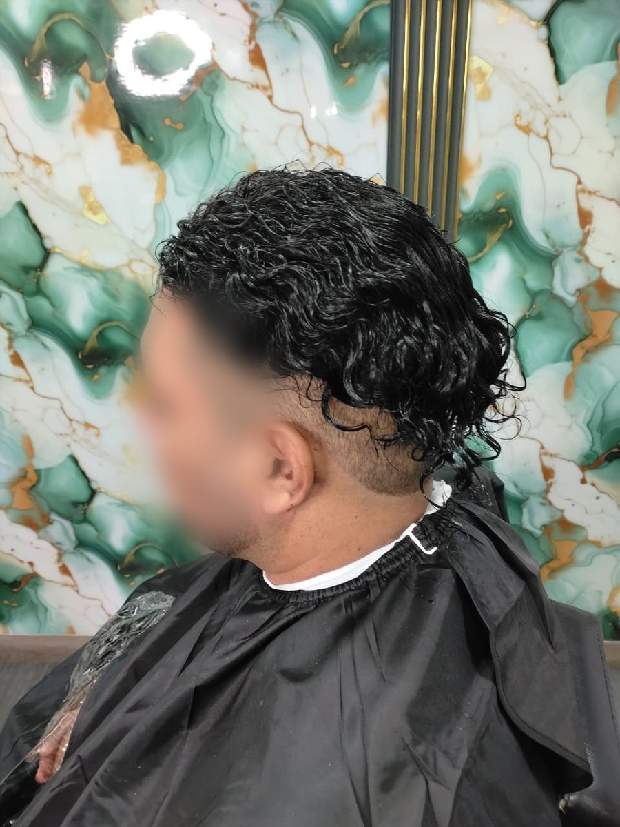 Con la prótesis de cabello rizado negro recién colocada, antes del corte